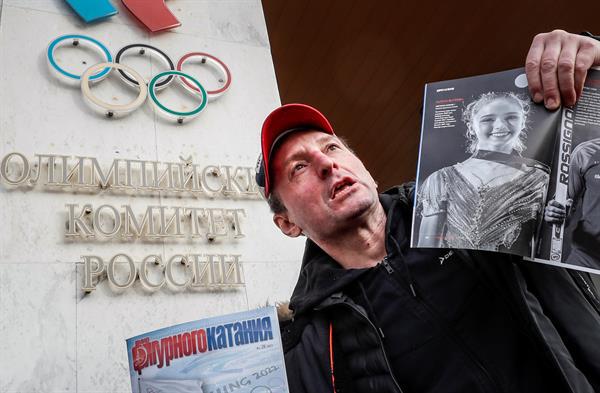 $!Un hombre frente al Comité Olímpico Ruso, llevando revistas con imágenes de Valieva y expresando su apoyo.