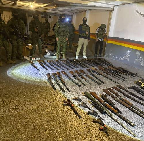Fotografía que muestra a militares custodiando las armas largas decomisadas.
