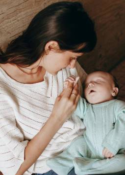 Foto una mamá cargando a su bebé en etapa de lactancia.