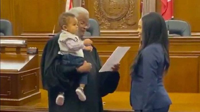 Juez sostiene a bebé de una abogada para tomarle juramento