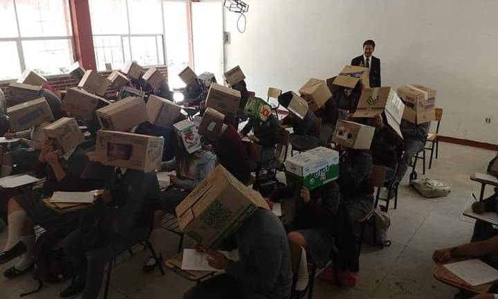 Profesor pone cajas de cartón sobre alumnos para que no copien