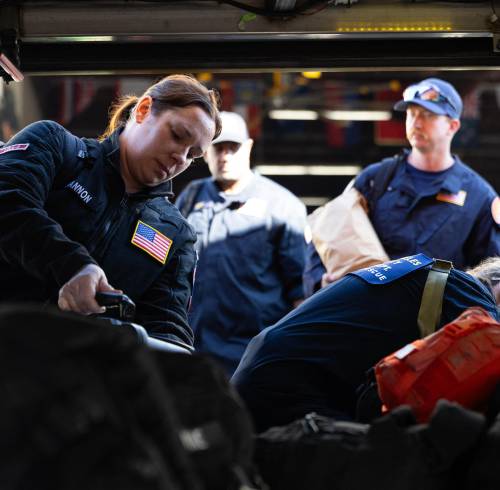 Miembros del equipo internacional de búsqueda y rescate urbano (USA-2) del Departamento de Bomberos del Condado de Los Ángeles cargan sus suministros en un autobús antes de partir hacia Venezuela.