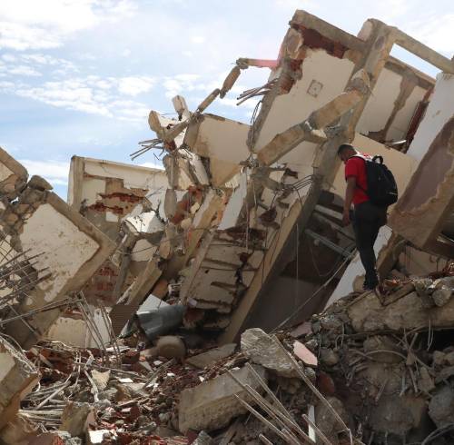 Un hombre camina sobre escombros de edificaciones destruidas este martes, en La Guaira (Venezuela).