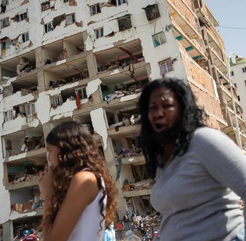 Personas reaccionan frente a edificios afectados por terremotos este jueves, en Catia La Mar.