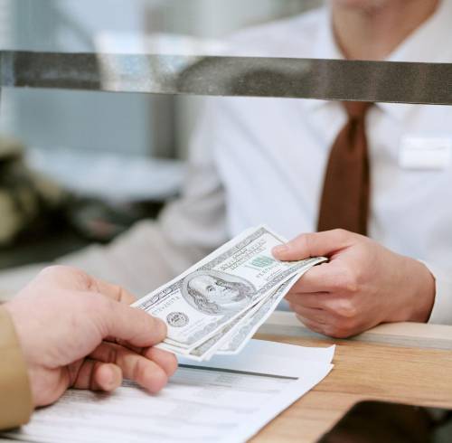 Una persona recibe dinero en una institución financiera.