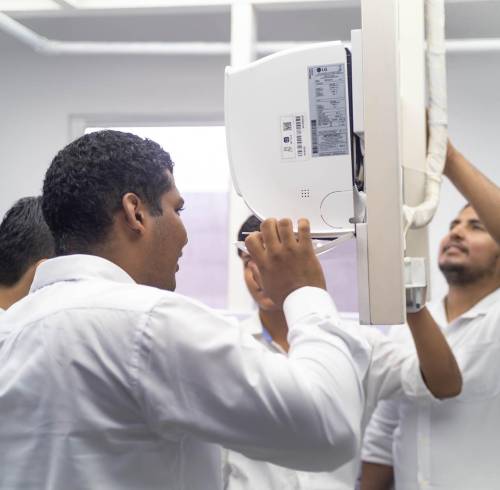 Un grupo de jóvenes capacitados en el programa LG Inverter Academy realizan trabajos en un aire acondicionado.