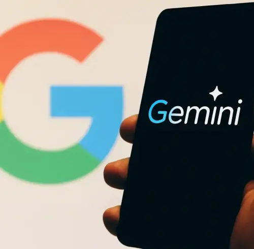 Hombre sujetando con la mano un teléfono celular con el logo de Gemini.
