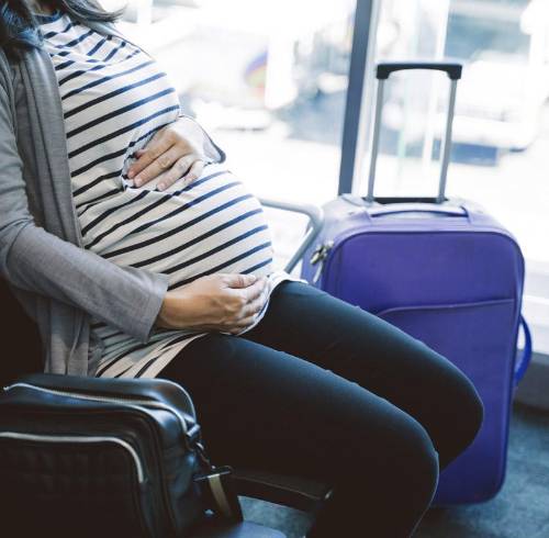 Fotografía referencial que muestra a una mujer embarazada esperando en un aeropuerto.