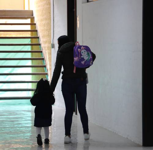 Fotografía referencial de una madre de familia tomando de la mano a su hija.
