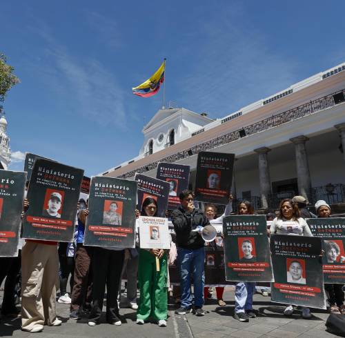 Familiares de personas desaparecidas sostienen carteles durante un plantón en el Palacio de Carondelet.