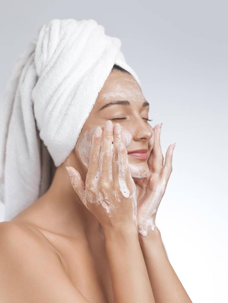 $!Mujer limpiando su rostro durante una rutina de skincare.