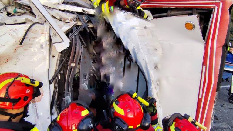 Personal del Cuerpo de Bomberos de Quito atiende el siniestro que dejó dos vehículos volcados.