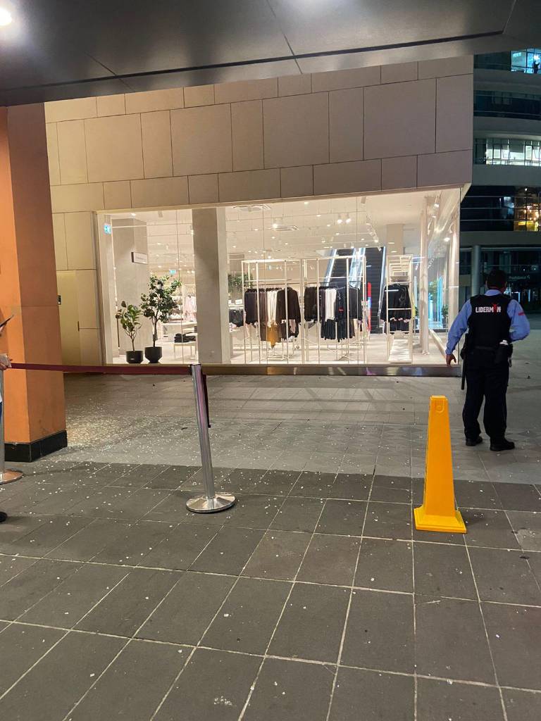 $!Restos del vehículo, como vidrio hecho añicos, salieron despedidos hasta uno de los accesos del concurrido centro comercial.