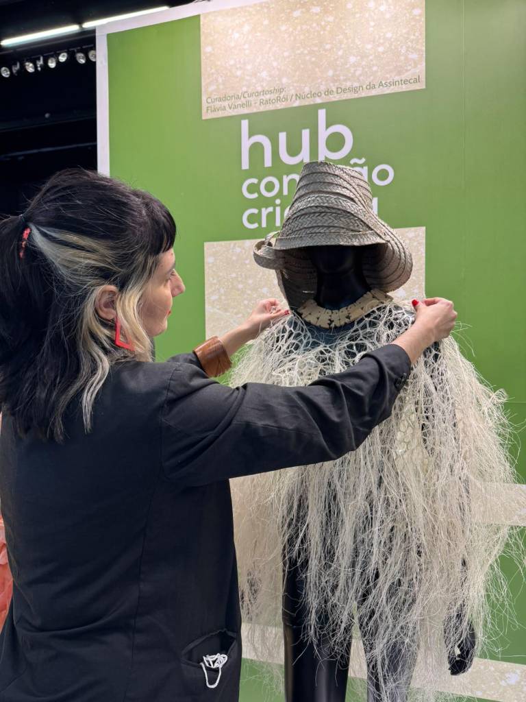 $!Flavia Vanelli, curadora del Núcleo de Design de Assitencal, revisa la exhibición Camuflaje con el collar del artista ecuatoriano Alfonso Ponce.