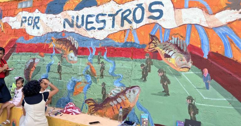 $!Militares, un hombre con traje y peces flotando, retratados en el mural en conmemoración a los menores del Caso Las Malvinas.
