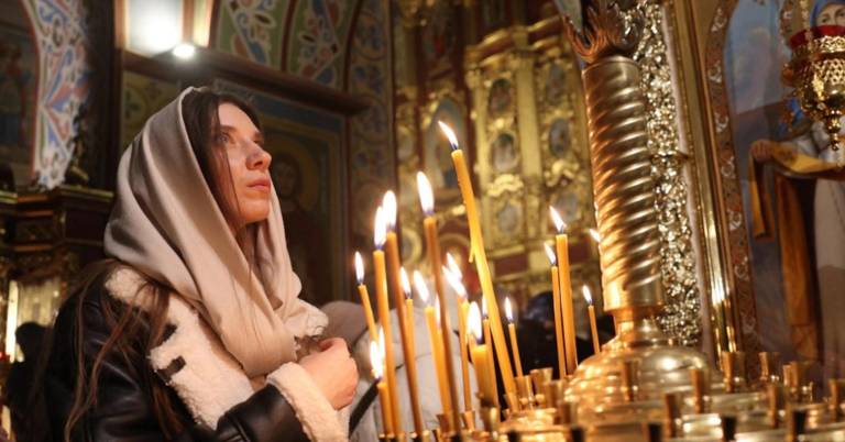 $!Una mujer enciende una vela en Nochebuena en Kiev, Ucrania.