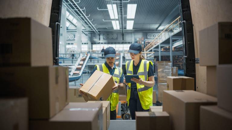 $!Trabajadores de una empresa logística revisan los detalles de entrega de la carga.