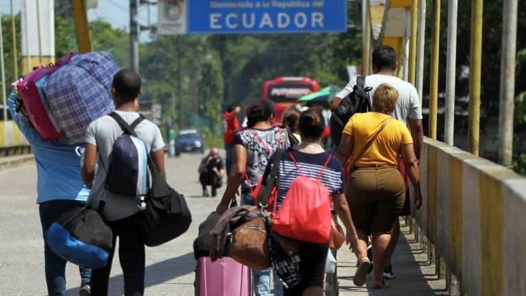 Imagen que muestra a migrantes cruzando a pie la frontera entre Ecuador y Colombia.