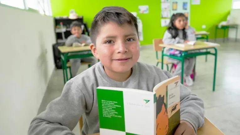 Estudiante de primaria en aula de clase con compañeros.