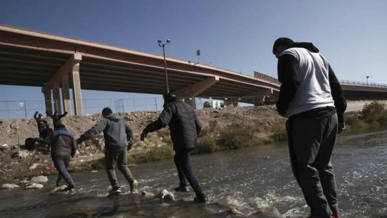 Migrantes cruzando un río en el trayecto de México hacia el norte.
