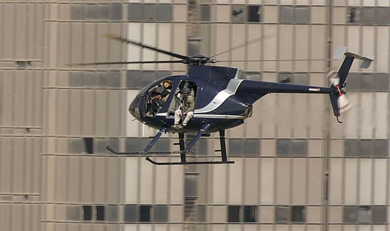 $!Miembros de la empresa de seguridad privada estadounidense Blackwater a bordo de un helicóptero Hughes 500 en Bagdad, el 8 de julio de 2006. (PATRICK BAZ / AFP)