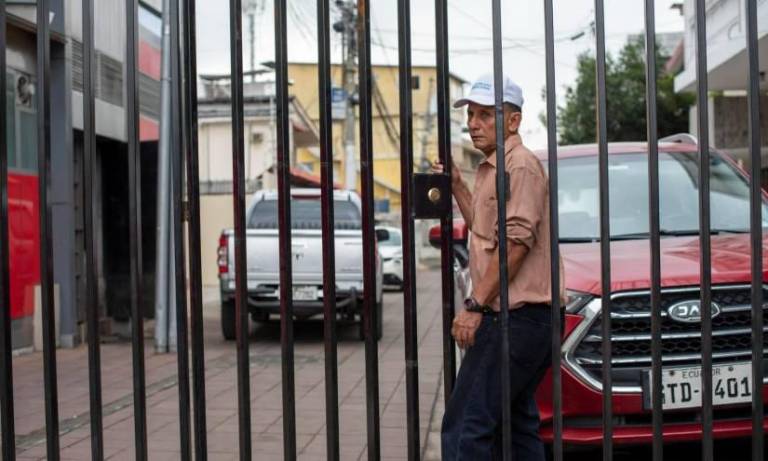 $!Fotografía de un residente de Guayaquil detrás de un portón metálico instalado en la calle donde vive.