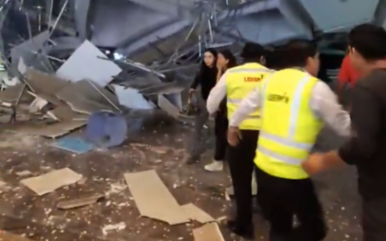 $!Dos jóvenes alejándose del área del colapso, mientras personal del centro comercial auxilia a heridos.