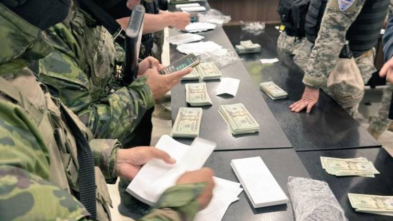 Fotografía que muestra a militares recogiendo billetes falsificados hallados en la Terminal de Quito.