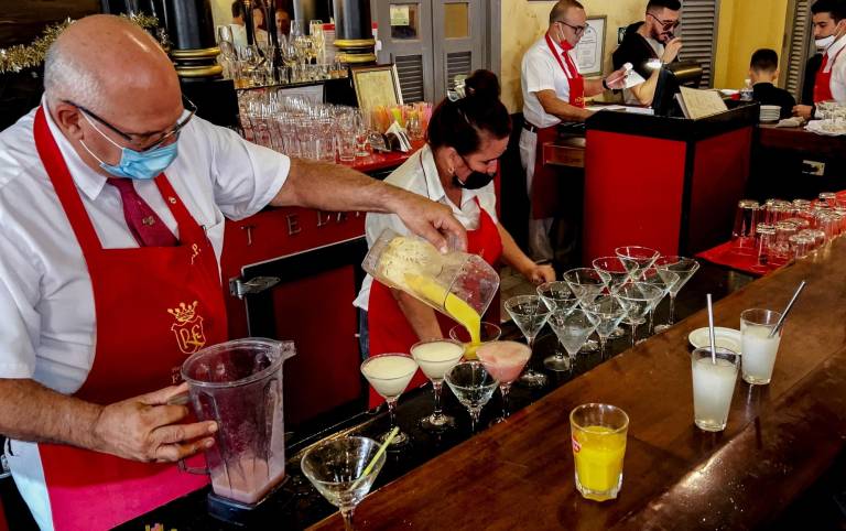 $!Varios bartenders sirven cócteles de daiquiri en el bar El Floridita, en La Habana.