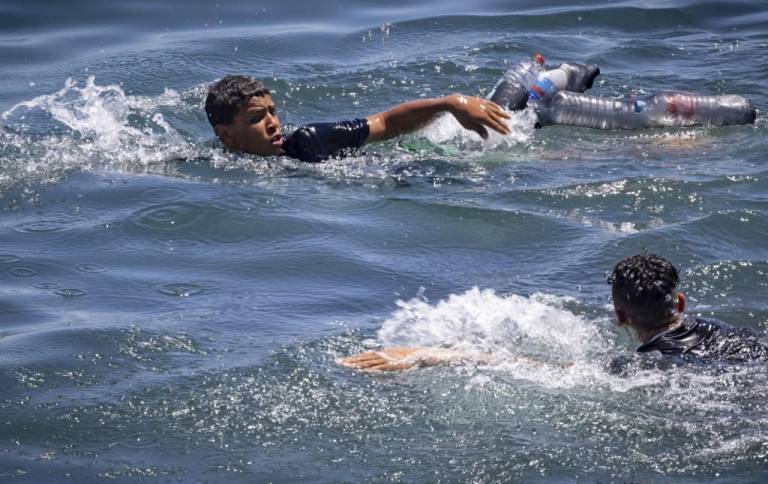 $!Migrantes marroquíes intentan nadar desde la ciudad norteña de Fnideq a través de la frontera con Marruecos hasta el enclave español de Ceuta en el norte de África.