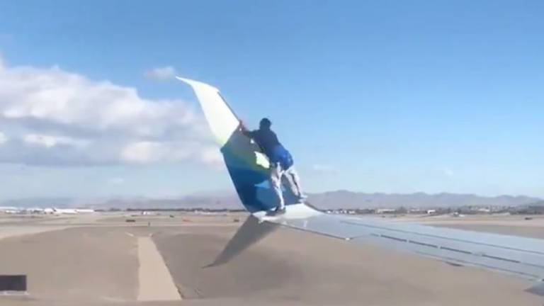 Doloroso final: el instante en que un hombre se sube al ala de un avión a punto de despegar