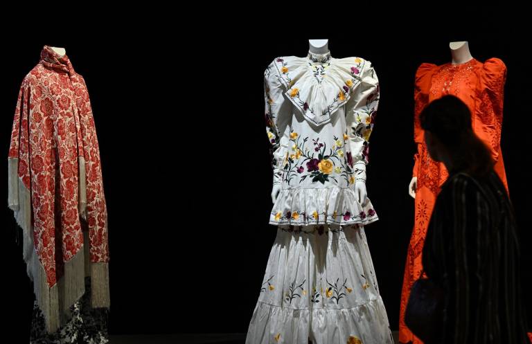 $!Un visitante mira las creaciones de la diseñadora de moda Tina Modotti inspiradas en la fallecida artista mexicana Frida Kahlo, durante una vista previa de la exposición Frida Kahlo, más allá de las apariencias en el Palais Galleria de París el 12 de septiembre de 2022. (Photo by Emmanuel DUNAND / AFP)