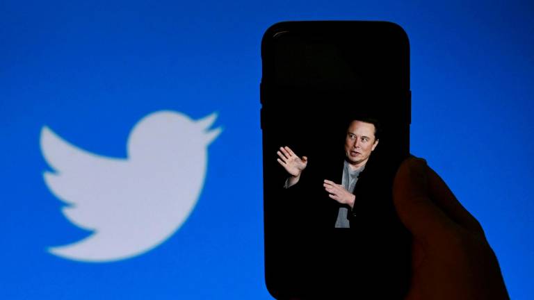 En esta foto ilustrativa de archivo tomada el 4 de octubre de 2022, la pantalla de un teléfono muestra una foto de Elon Musk con el logotipo de Twitter de fondo en Washington, DC.
