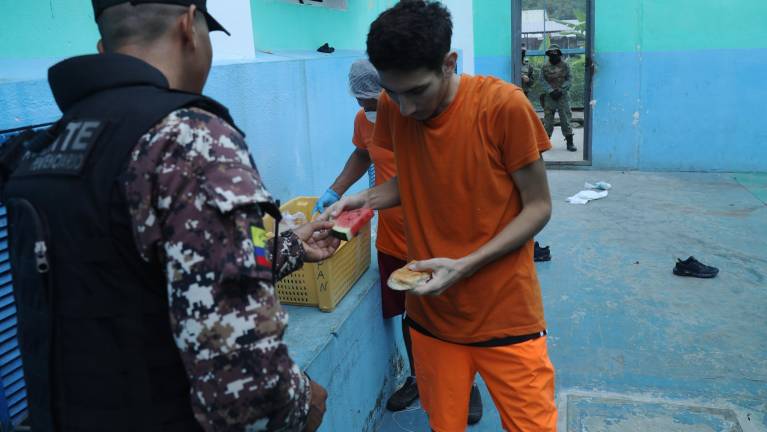 Fotografía de reos recibiendo alimentos en el Centro de Privación de Libertad El Rodeo, en Portoviejo.