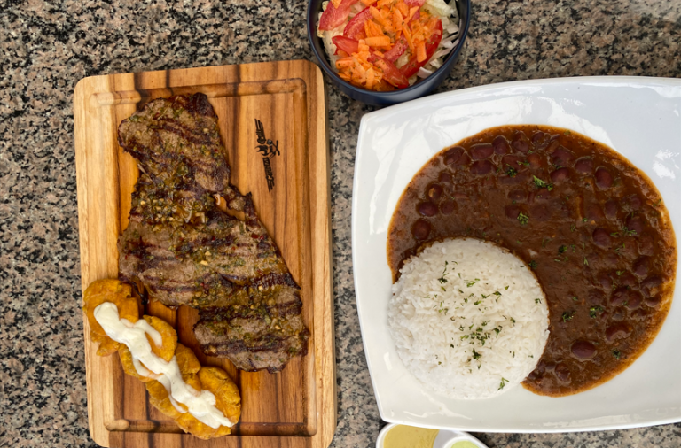$!Foto de plato típico guayaquileños, arroz con menestra y carne asada del restaurante Central Grill 593, que se encuentra en 'Mercado del Río', el cual ofrece el 'Festival La Cuchara Juliana' en honor a las fiestas de Guayaquil.