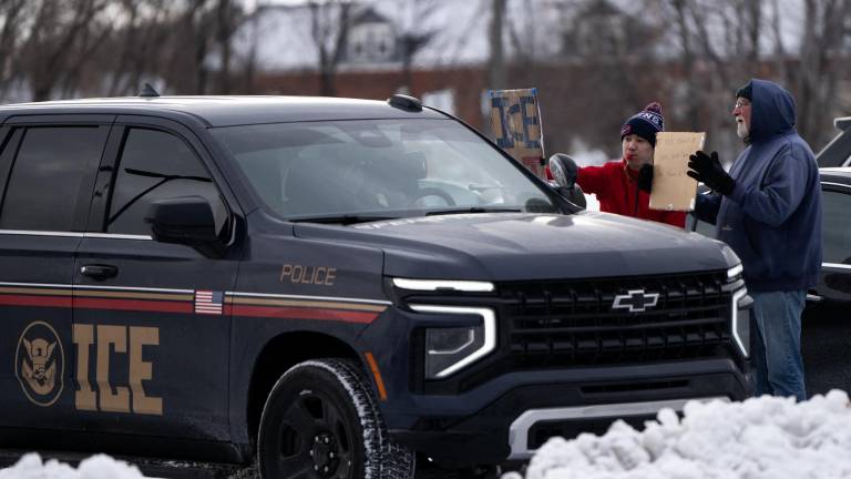 La gente se enfrenta a un agente en un vehículo de ICE cerca de la sede regional de ICE en el edificio federal Bishop Henry Whipple el 10 de enero de 2026 en Minneapolis, Minnesota.
