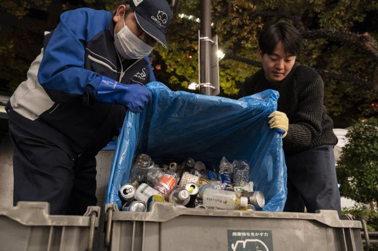 $!Esta foto realizada en noviembre de 2022 muestra a un trabajador (izquierda) del Shirai Eco Center y Taiju Takano (derecha), productor jefe de la compañía de danza K-BALLET, recolectando botellas de plástico en Tokio.
