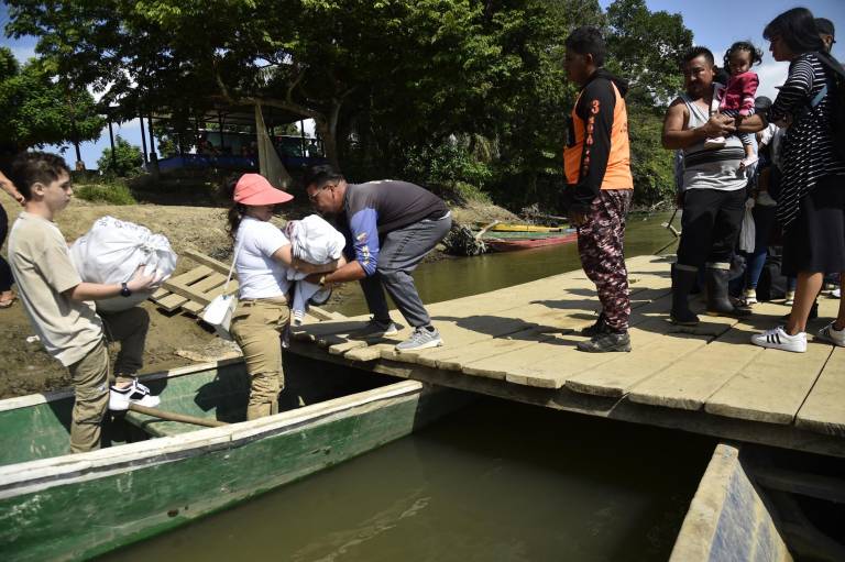 $!Desplazados por los recientes enfrentamientos entre grupos armados abordan canoas para cruzar el río Tarra, que divide a Colombia y Venezuela.