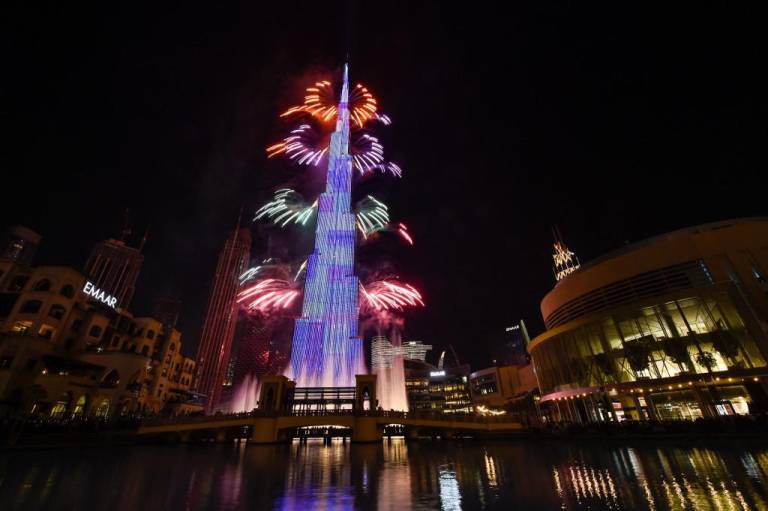 $!Una foto tomada el 31 de diciembre de 2021 muestra fuegos artificiales en erupción desde el Burj Khalifa en el emirato del Golfo de Dubai como parte de las festividades de Año Nuevo.