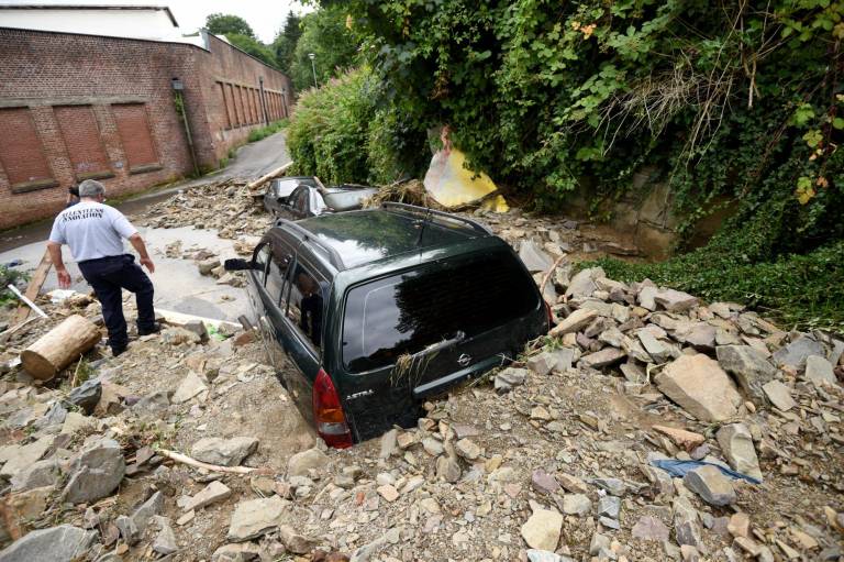 $!Un hombre camina cerca de un derrumbe causado por las fuertes lluvias.