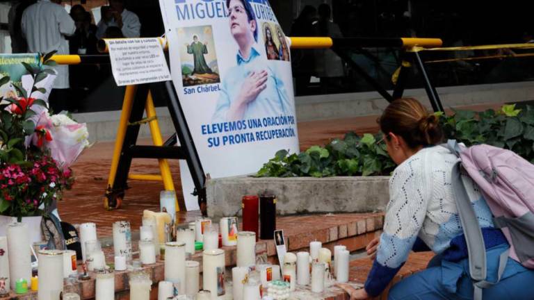 Una mujer pone velas en un altar para pedir por la recuperación del senador y precandidato presidencial colombiano Miguel Uribe Turbay.