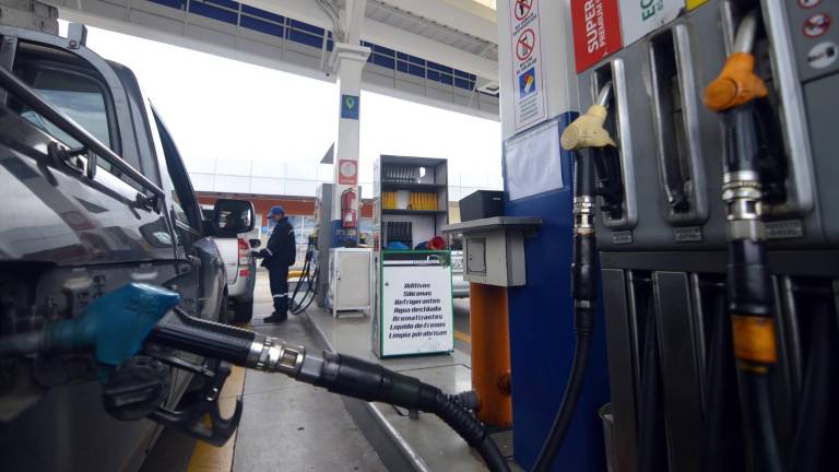 Despachador atiende a un vehículo que recargará de combustible en una gasolinera de Cuenca.