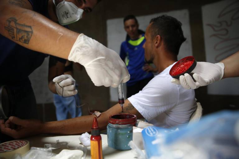 $!Una persona dona sangre que será utilizada por el artista Julián Castillo para pintar un retrato del cantante puertorriqueño Residente, en el barrio Siloé, en Cali (Colombia).