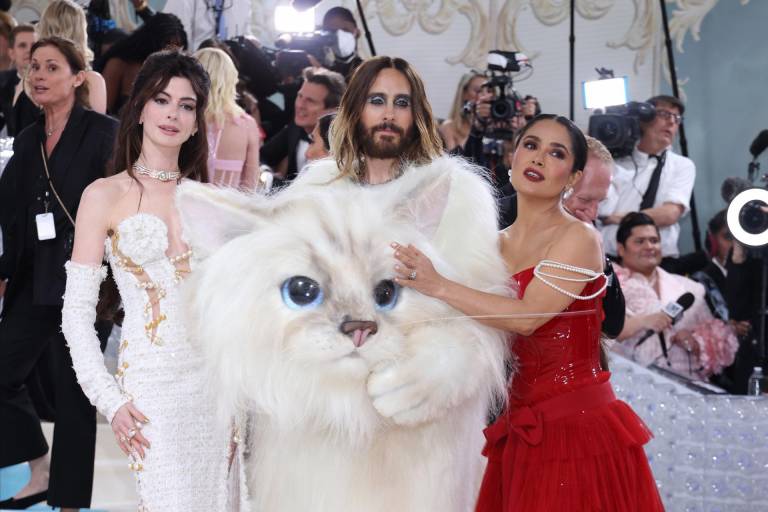 $!Las actrices Anne Hathaway y Salma Hayek, quien vistió un diseño en rojo de Gucci, no dudaron en fotografiarse con el actor Jared Leto quien llevó un disfraz en alusión a la querida mascota de Lagerfeld.