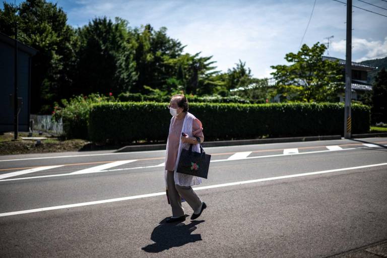 $!Esta fotografía tomada el 30 de agosto de 2023 muestra a la asesora de belleza Tomoko Horino, de 100 años, esperando un autobús para ir a la oficina en la ciudad de Fukushima.