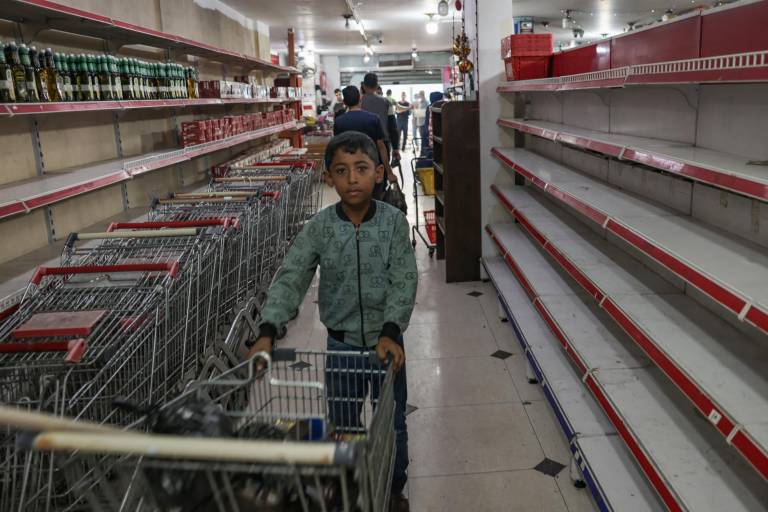 $!Un niño palestino se encuentra cerca de conchas vacías en un supermercado en Rafah, en el sur de la Franja de Gaza, el 13 de noviembre de 2023, en medio de las batallas en curso entre Israel y el grupo militante palestino Hamás.