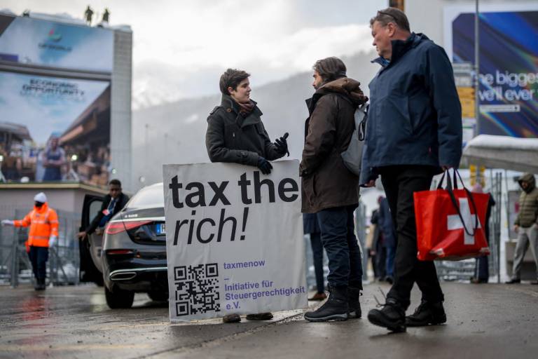 $!La austriaca Marlene Engelhorn, que heredó de su familia la propiedad del gigante químico alemán BASF, posa con un cartel que dice ¡Cobren impuestos a los ricos!, en la entrada del centro de congresos en la inauguración de la reunión anual del Foro Económico Mundial (FEM) en Davos, el 15 de enero de 2024.