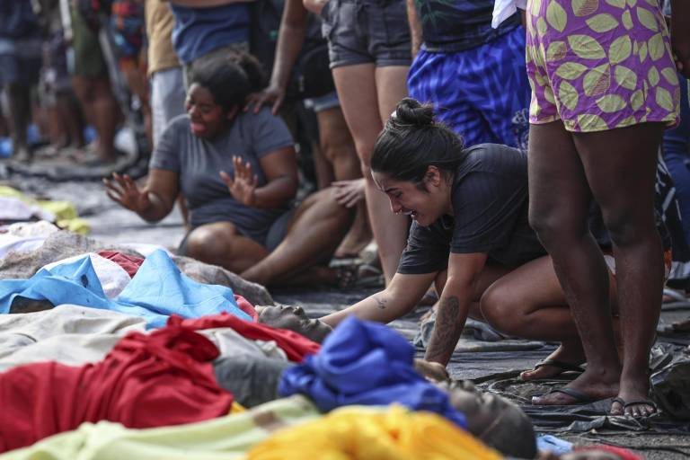 $!Una mujer llora frente a cuerpos sin vida en una calle este miércoles, en Río de Janeiro.