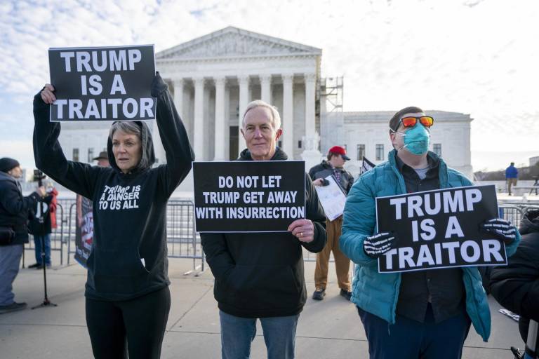 $!Protestantes sostienen carteles en frente de la Corte Suprema en Washington. A pesar de sus problemas legales, Trump es un firme contendiente para ocupar la Casa Blanca.
