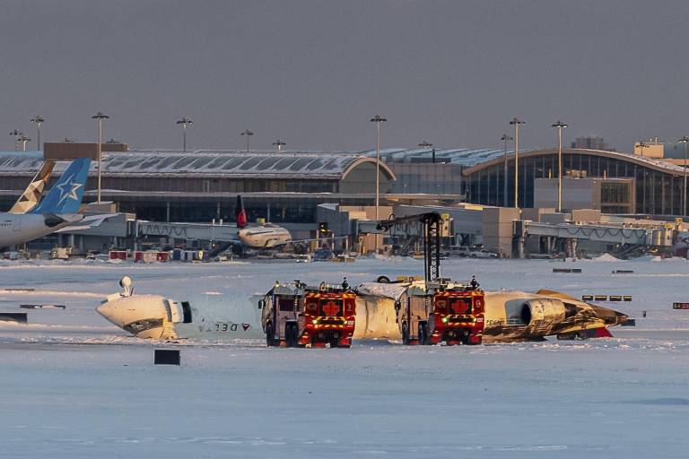 $!Los equipos de emergencia se reúnen en el lugar del accidente donde un vuelo de Delta Air Lines volcó
